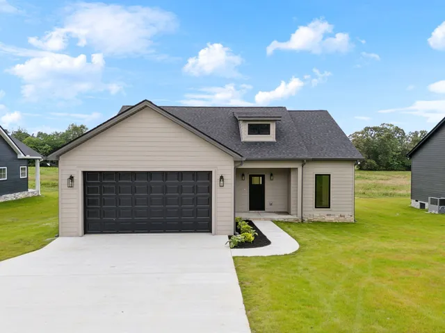 a view of a house with a yard and garage