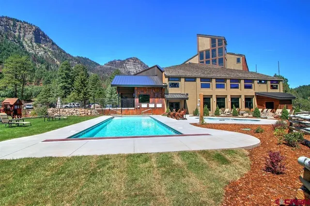 a view of a house with pool and chairs