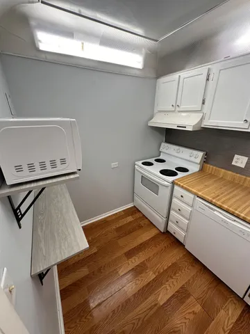 a kitchen with white cabinets and appliances