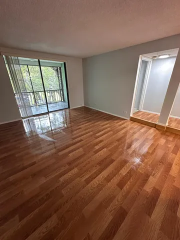 a view of empty room with wooden floor