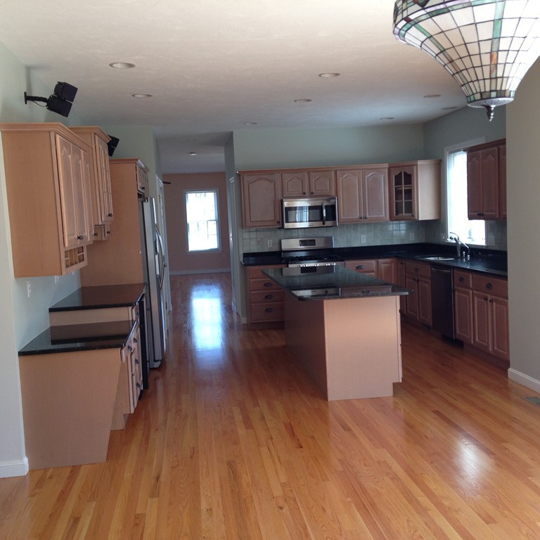 48 Independence Lane Ashland, MA 01721 - Photo 8 of 30 a kitchen with stainless steel appliances granite countertop a stove a sink dishwasher and a refrigerator with wooden floor