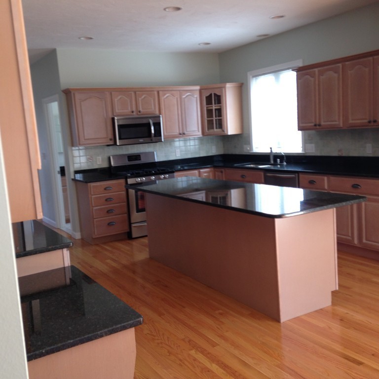 48 Independence Lane Ashland, MA 01721 - Photo 9 of 30 a kitchen with stainless steel appliances granite countertop a stove a sink and a microwave