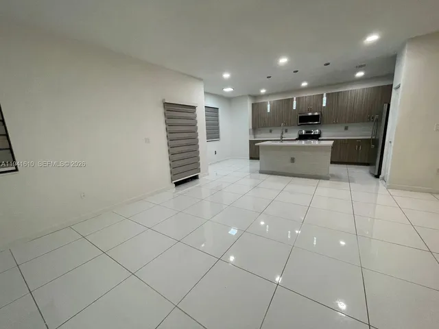 a large white kitchen with a sink and cabinets