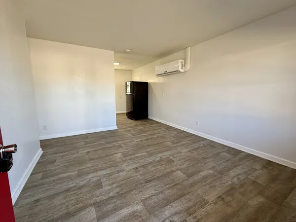 a view of empty room with wooden floor
