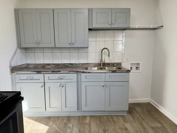 a kitchen with stainless steel appliances granite countertop white cabinets and sink