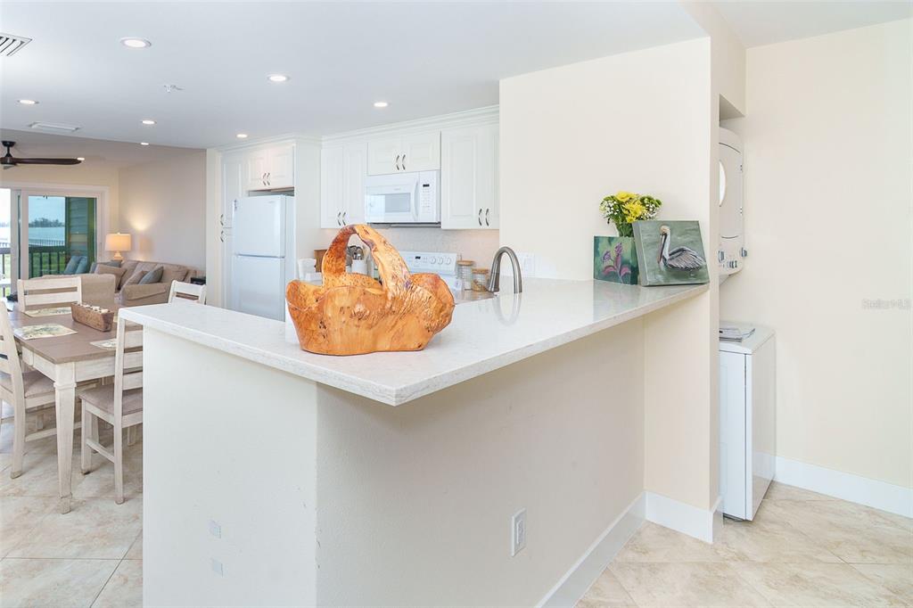 9200 Little Gasparilla, Unit 403 Boca Grande, FL 33921 - Photo 12 of 38 a kitchen with stainless steel appliances granite countertop a sink a stove and a refrigerator