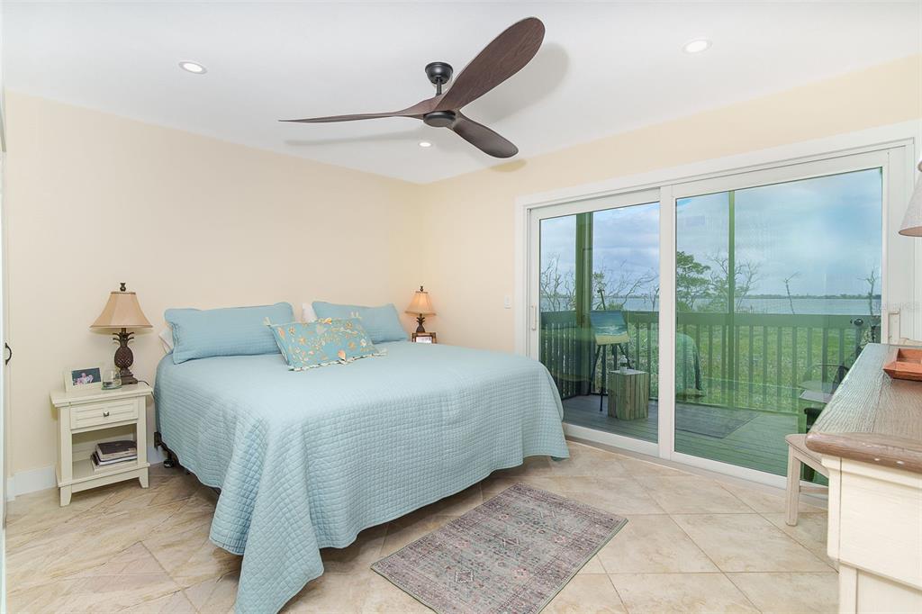 9200 Little Gasparilla, Unit 403 Boca Grande, FL 33921 - Photo 15 of 38 a spacious bedroom with a bed and a large window