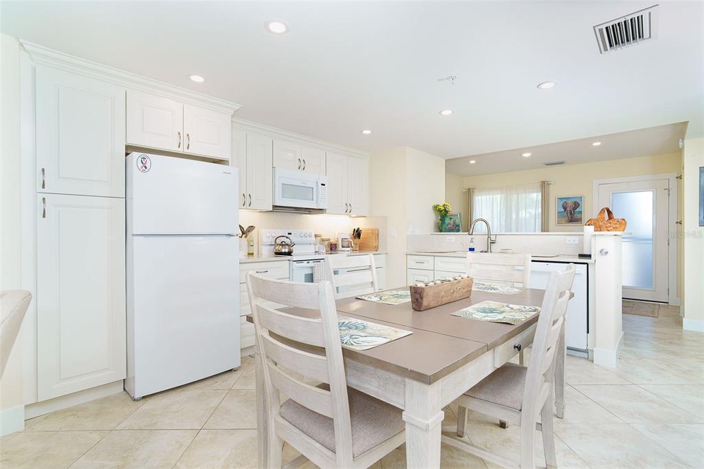 9200 Little Gasparilla, Unit 403 Boca Grande, FL 33921 - Photo 9 of 38 a kitchen with a refrigerator a stove and a dining table