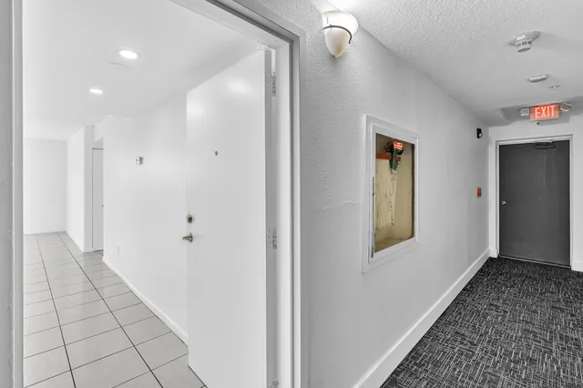 a view of an empty room and kitchen