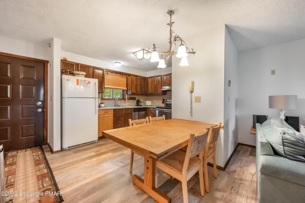 a kitchen with stainless steel appliances kitchen island granite countertop a refrigerator a stove a oven and a sink with island