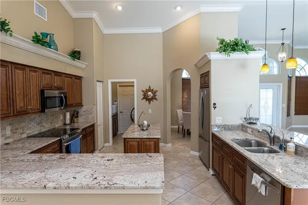 a kitchen with kitchen island granite countertop a sink stove and refrigerator
