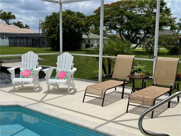 a view of a patio with a table chairs and a backyard