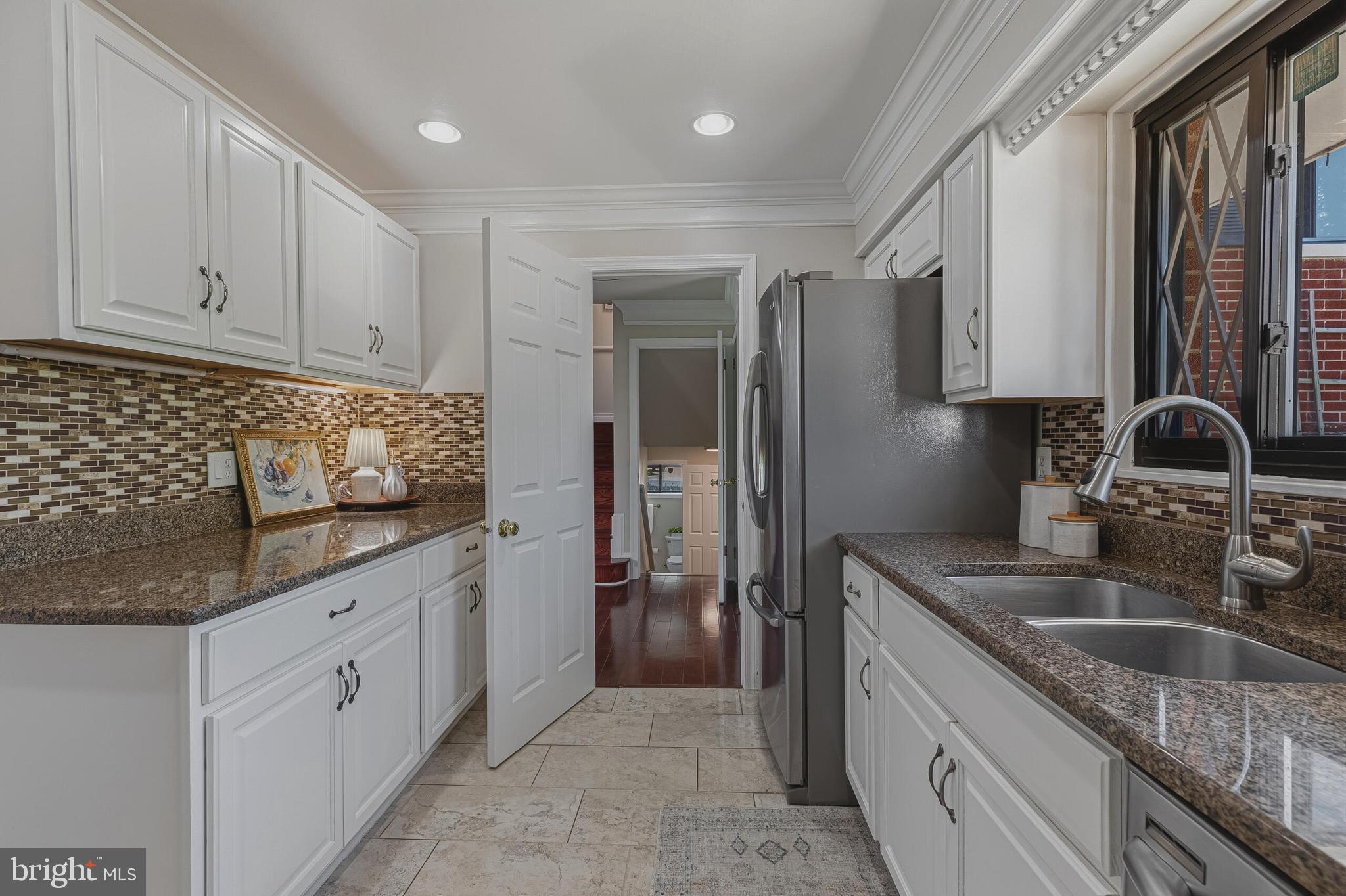 5917 Flanders Street Springfield, VA 22150 - Photo 11 of 40 a kitchen with granite countertop a sink stove and refrigerator