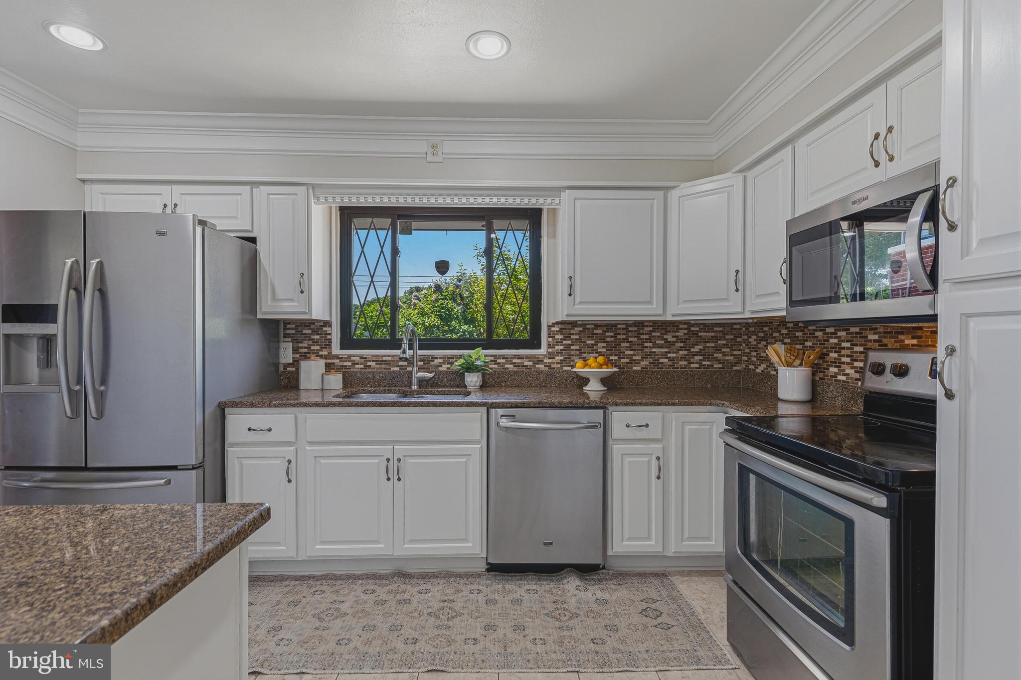 5917 Flanders Street Springfield, VA 22150 - Photo 12 of 40 a kitchen with stainless steel appliances granite countertop a sink stove and refrigerator