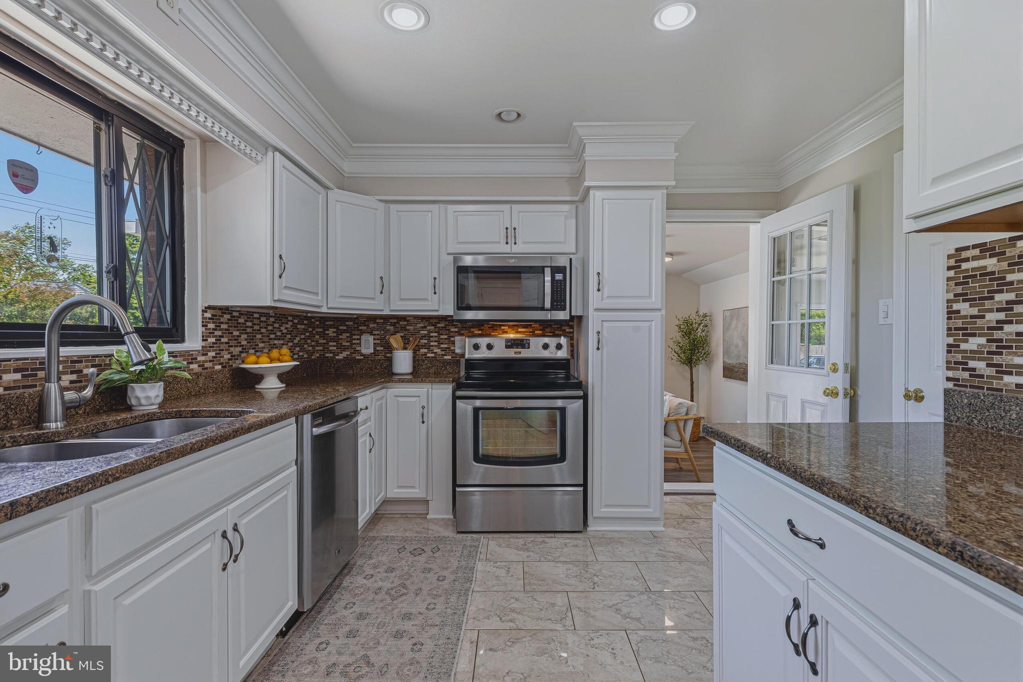 5917 Flanders Street Springfield, VA 22150 - Photo 13 of 40 a kitchen with granite countertop a stove and a sink