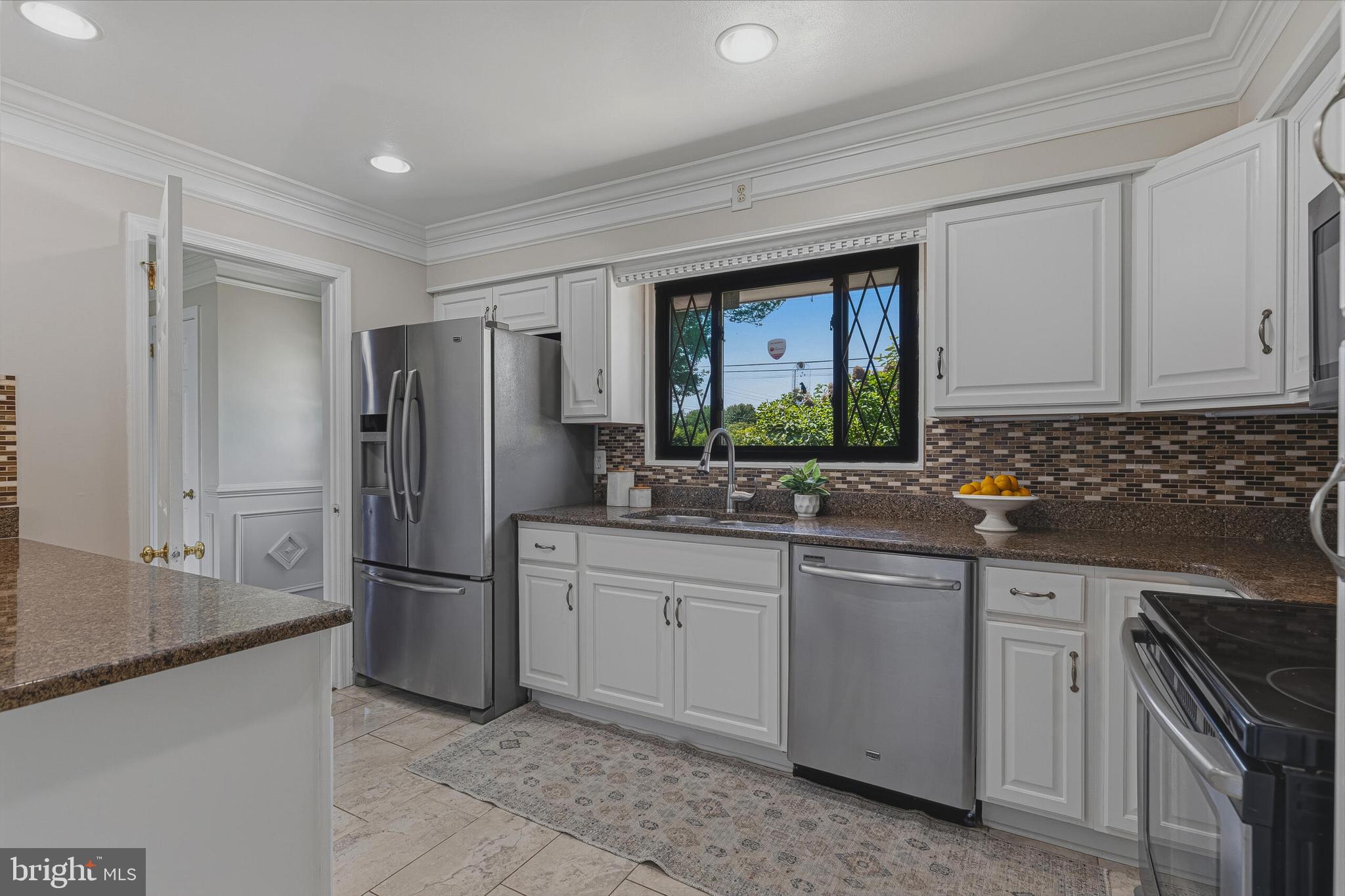 5917 Flanders Street Springfield, VA 22150 - Photo 14 of 40 a kitchen with granite countertop a refrigerator and a sink