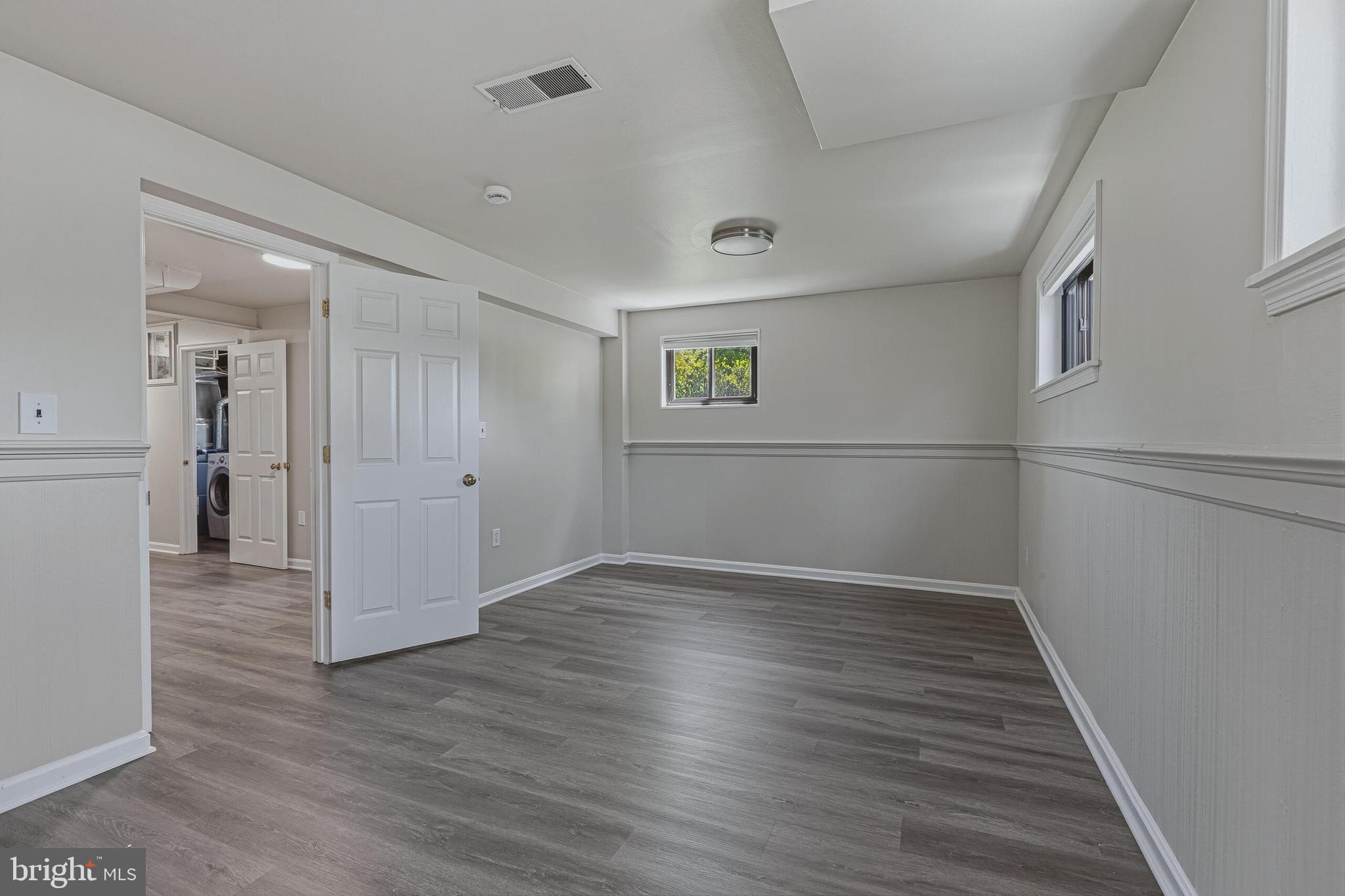 5917 Flanders Street Springfield, VA 22150 - Photo 32 of 40 an empty room with wooden floor and windows