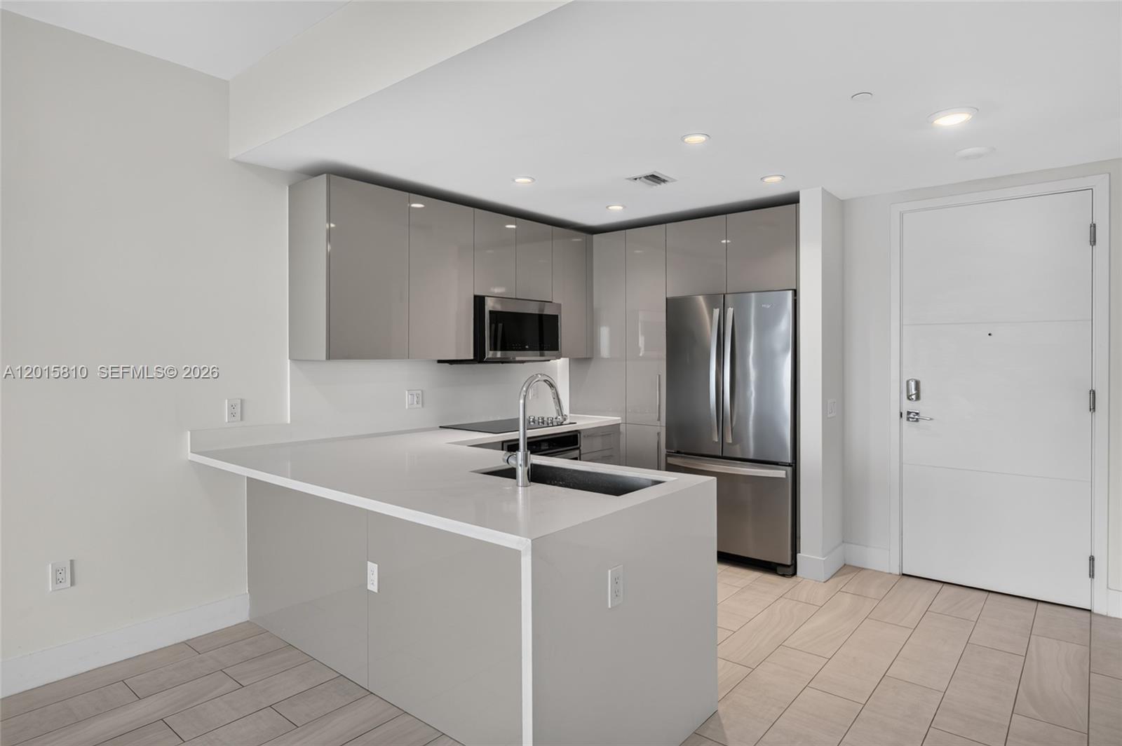2000 Metropica Way, Unit 1902 Sunrise, FL 33323 - Photo 6 of 40 a kitchen with stainless steel appliances a refrigerator sink and microwave