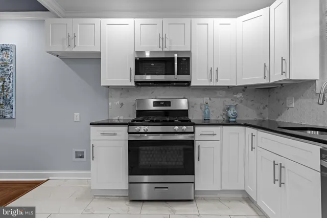 a kitchen with white cabinets and stainless steel appliances