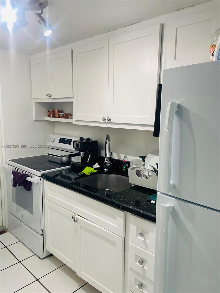 335 Collins Avenue, Unit 302 Miami Beach, FL 33139 - Photo 11 of 19 a kitchen with stainless steel appliances granite countertop a sink stove and refrigerator