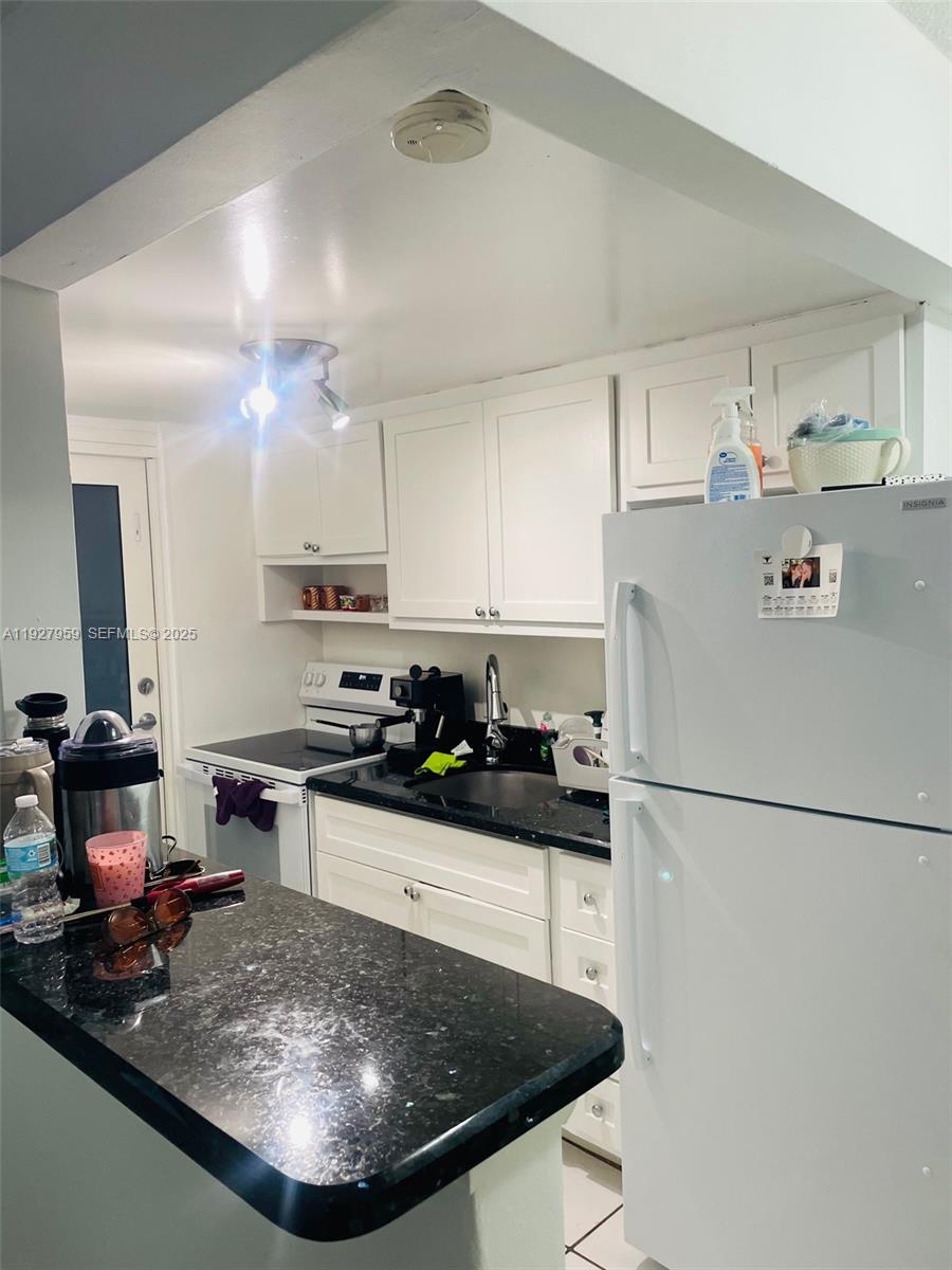 335 Collins Avenue, Unit 302 Miami Beach, FL 33139 - Photo 10 of 19 a kitchen with stainless steel appliances granite countertop a sink stove and refrigerator