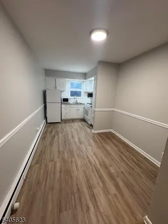a view of a room with wooden floor and electronic appliances