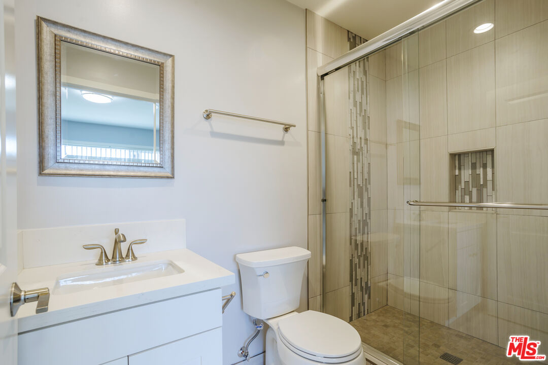 1116 San Rafael Avenue, Unit 6 Glendale, CA 91202 - Photo 19 of 23 a bathroom with a toilet a sink a shower and a mirror