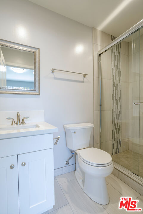 1116 San Rafael Avenue, Unit 6 Glendale, CA 91202 - Photo 20 of 23 a bathroom with a granite countertop sink toilet a mirror a vanity and shower