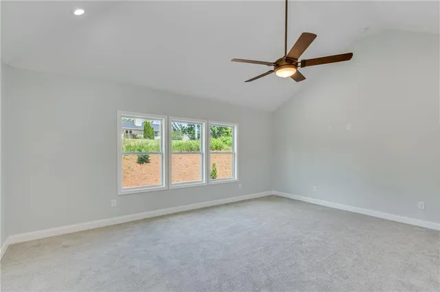 a view of empty room with a ceiling fan and window