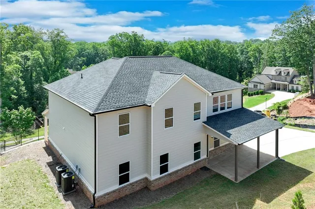 a aerial view of a house in front of a yard with potted plants