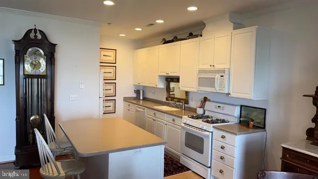 a kitchen with a stove a refrigerator and furniture