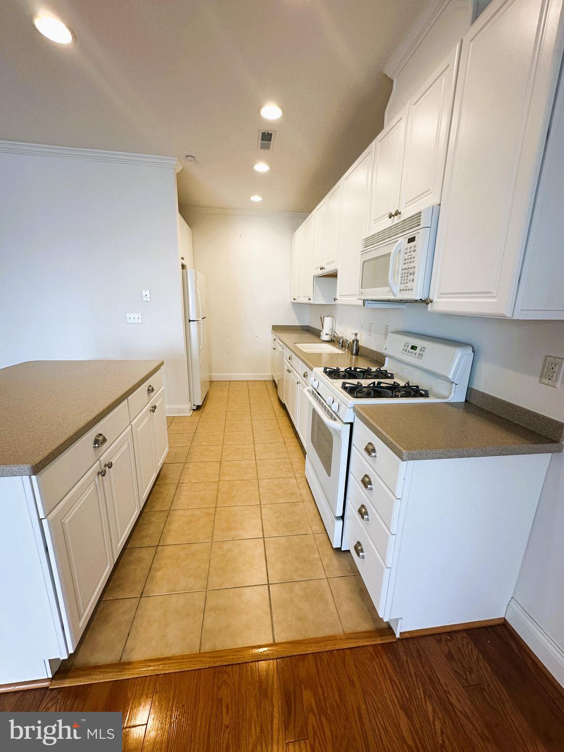 5 Oakley Street, Unit 102 Cambridge, MD 21613 - Photo 7 of 35 Galley kitchen with corian countertops