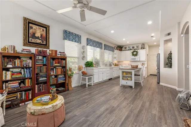 a kitchen with stainless steel appliances wooden floor and chairs