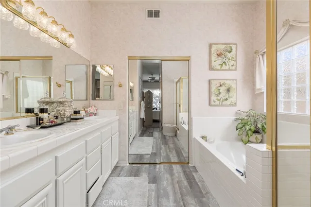 a spacious bathroom with a tub shower and mirror