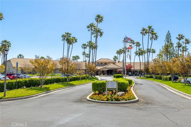 a view of a swimming pool with a yard and palm trees