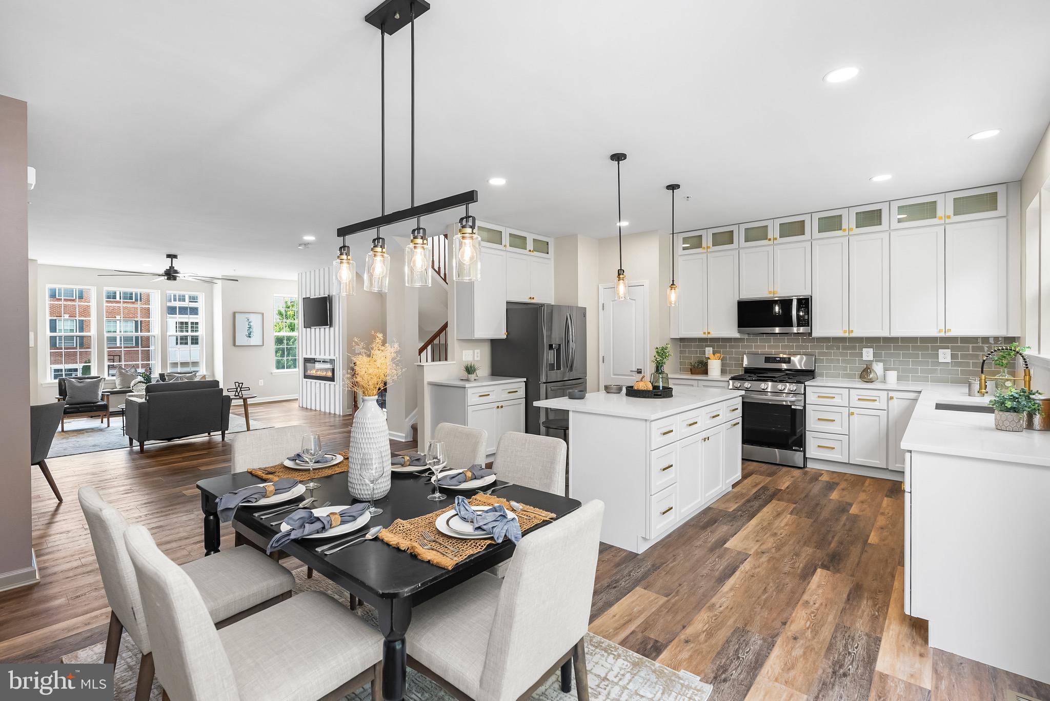 913 Sandy Run Road Middle River, MD 21220 - Photo 10 of 40 a kitchen with stainless steel appliances kitchen island granite countertop a stove top oven a sink a dining table and chairs with wooden floor