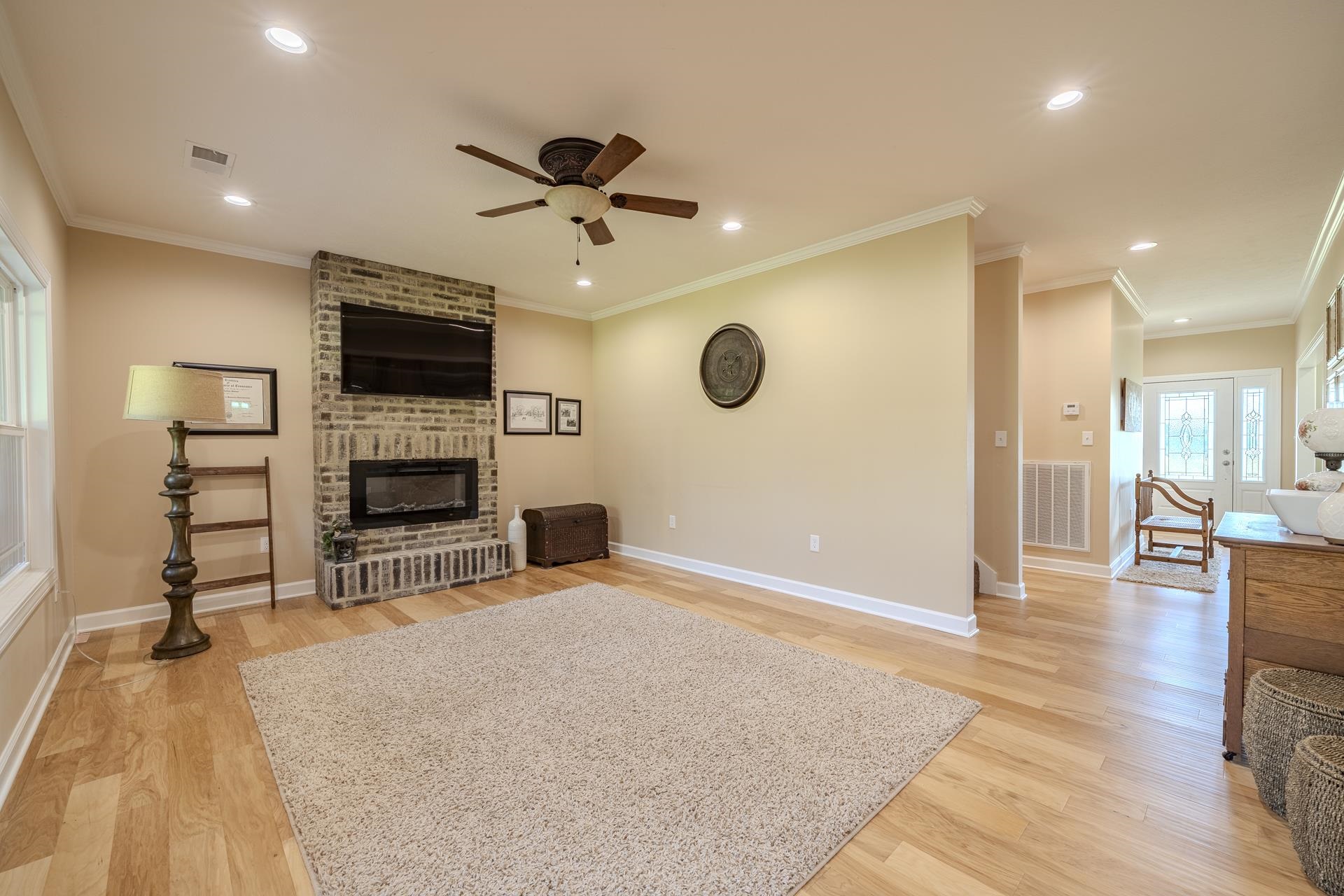 170 Kirk Cove Adamsville, TN 38310 - Photo 9 of 39 Living room featuring a ceiling fan, light wood finished floors, a brick fireplace, recessed lighting, and ornamental molding
