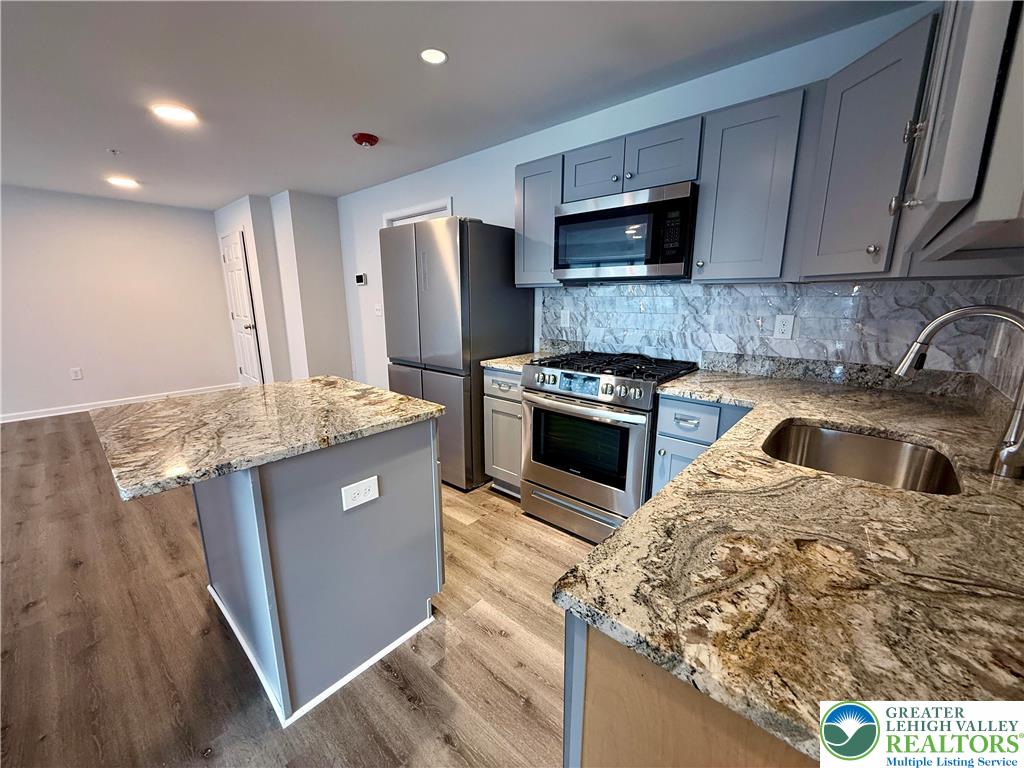 938 East 4th Street, Unit G03 Bethlehem, PA 18015 - Photo 20 of 30 a kitchen with stainless steel appliances granite countertop a sink stove and refrigerator