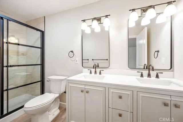 a bathroom with a sink toilet vanity and shower