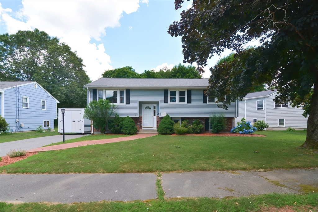 16 August Drive Framingham, MA 01701 - Photo 2 of 27 a front view of a house with a yard and garage