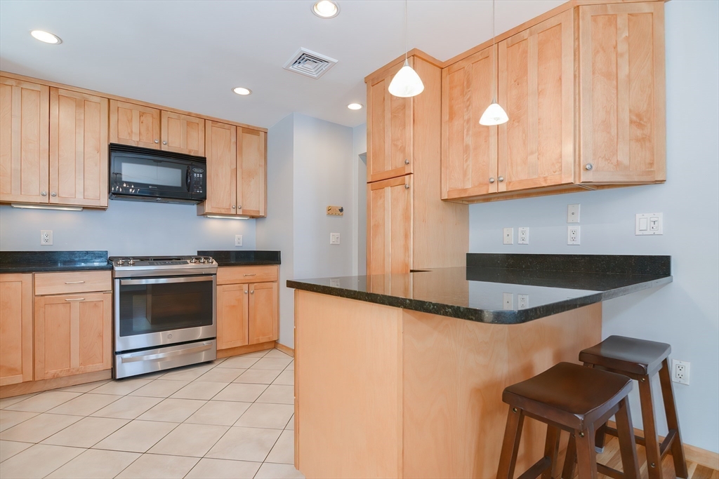 16 August Drive Framingham, MA 01701 - Photo 8 of 27 a kitchen with stainless steel appliances granite countertop a stove a sink and a microwave