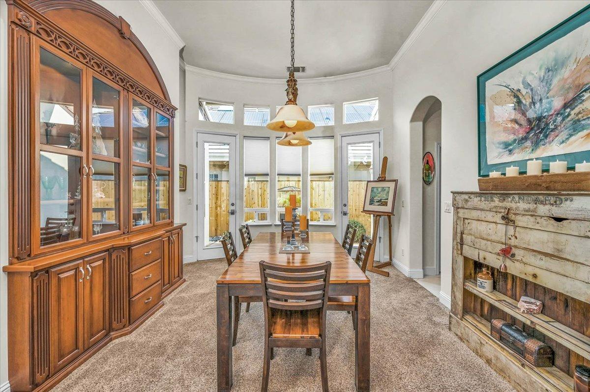 4574 North Quail Lake Drive Clovis, CA 93619 - Photo 16 of 77 a view of a dining room with furniture a chandelier and large windows
