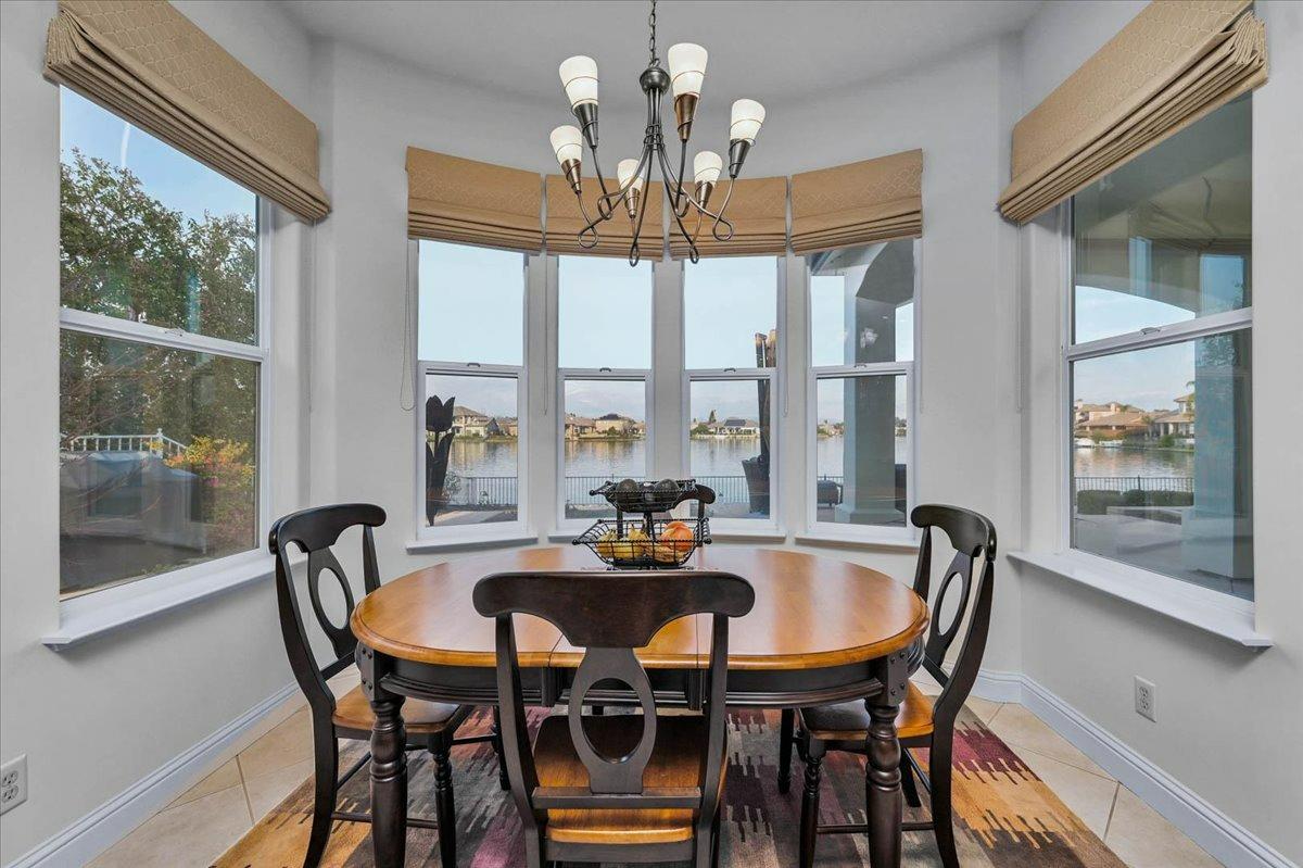 4574 North Quail Lake Drive Clovis, CA 93619 - Photo 17 of 77 a dining room with furniture a chandelier and a large window