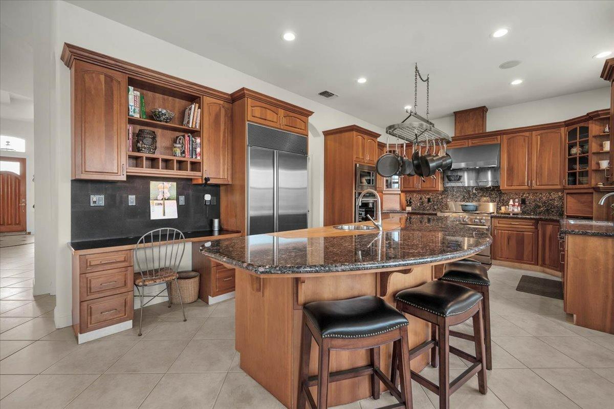 4574 North Quail Lake Drive Clovis, CA 93619 - Photo 18 of 77 a kitchen with stainless steel appliances kitchen island granite countertop a table and chairs
