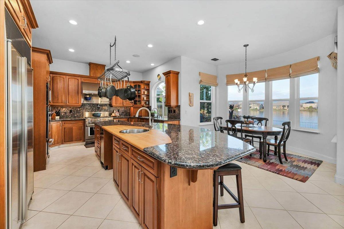 4574 North Quail Lake Drive Clovis, CA 93619 - Photo 19 of 77 a kitchen with stainless steel appliances granite countertop a stove a sink a refrigerator and a dining table