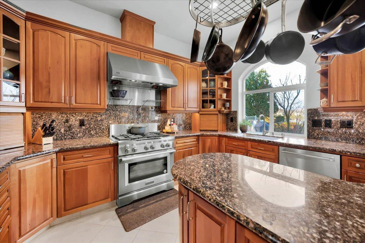 4574 North Quail Lake Drive Clovis, CA 93619 - Photo 20 of 77 a kitchen with stainless steel appliances granite countertop a sink a stove and a wooden cabinets