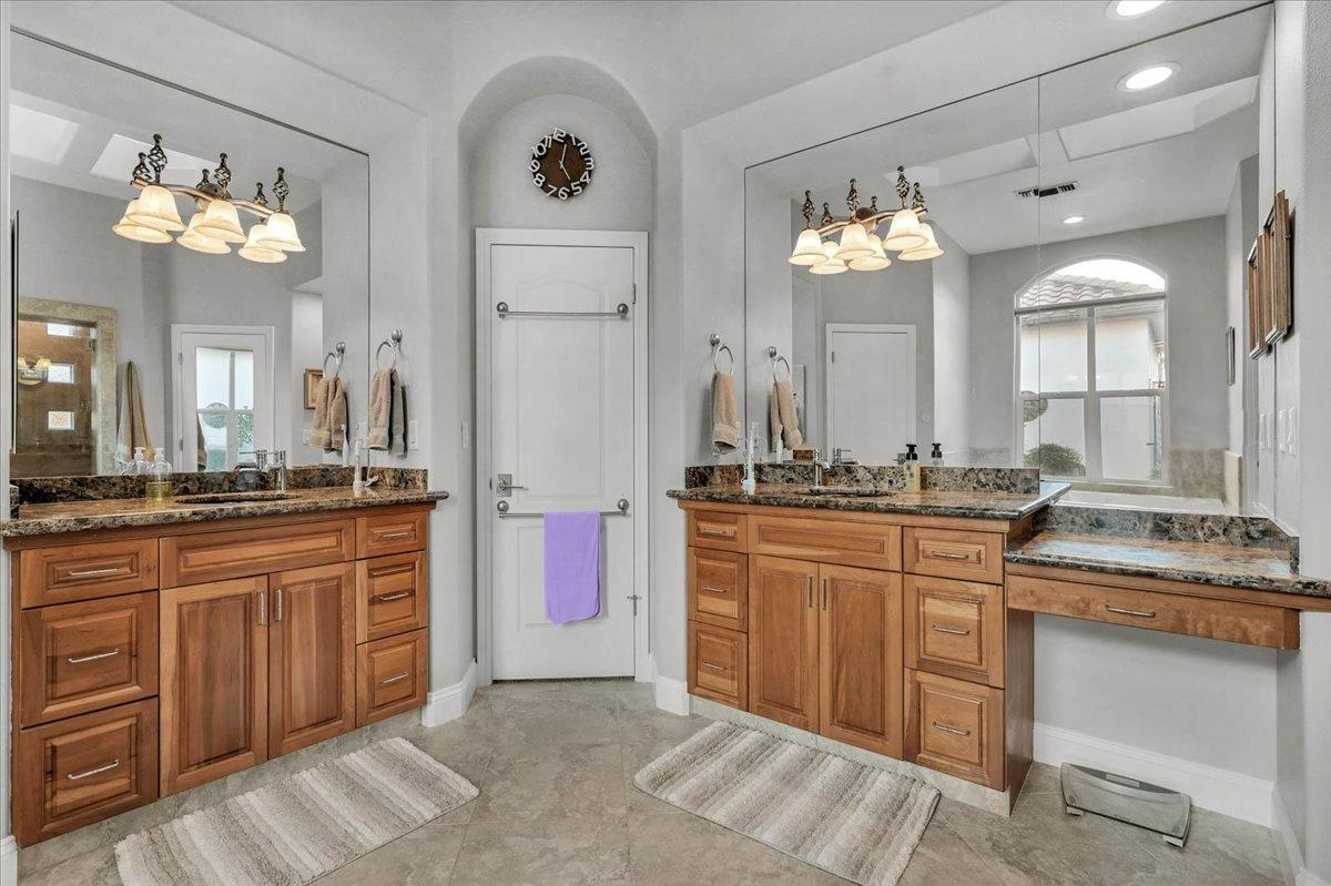 4574 North Quail Lake Drive Clovis, CA 93619 - Photo 32 of 77 a large bathroom with a sink vanity granite tub and a mirror