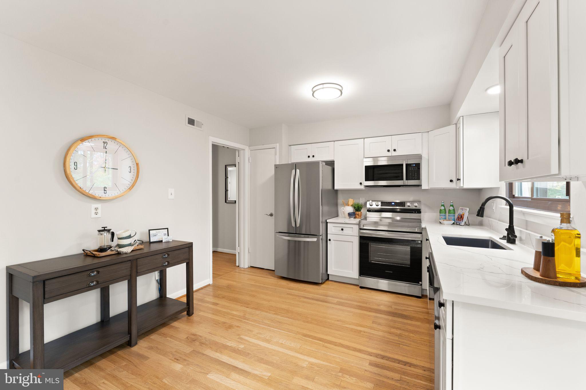 11917 Escalante Court Reston, VA 20191 - Photo 18 of 51 a kitchen with a refrigerator a stove top oven a sink dishwasher and wooden cabinets
