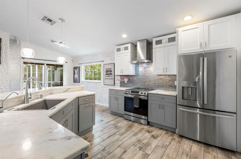 9641 Fulton Avenue Hudson, FL 34667 - Photo 14 of 60 a large kitchen with cabinets stainless steel appliances and a window