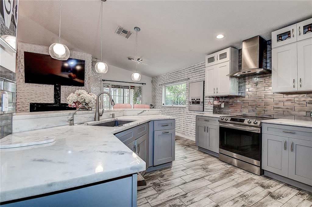 9641 Fulton Avenue Hudson, FL 34667 - Photo 15 of 60 a kitchen with stainless steel appliances granite countertop a sink a stove and a microwave